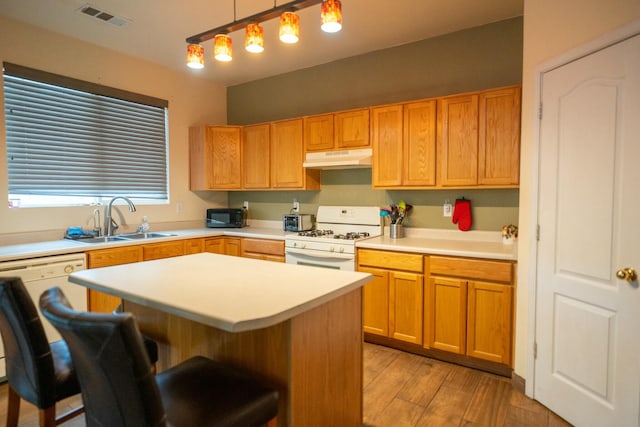 kitchen with under cabinet range hood, a sink, visible vents, dishwasher, and white gas range