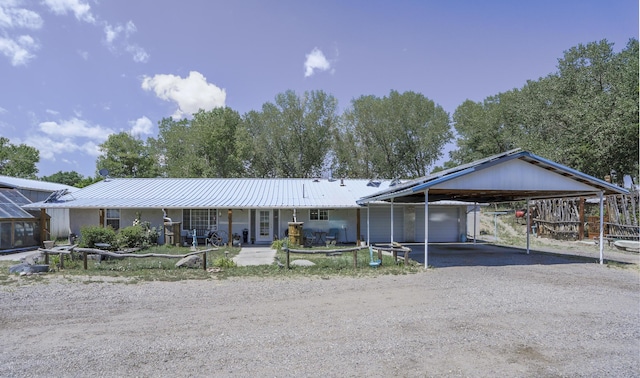 single story home with metal roof, driveway, and an attached carport