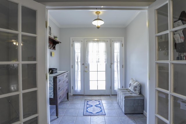 doorway to outside with light tile patterned floors, crown molding, and a wealth of natural light