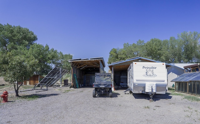 view of front of house featuring a carport and an outdoor structure