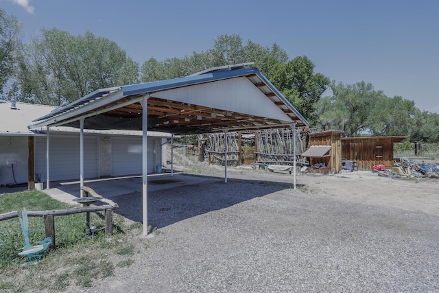 view of vehicle parking with gravel driveway and a carport