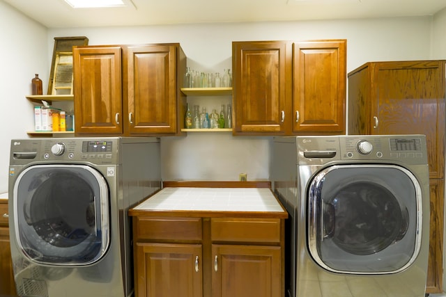 laundry room featuring separate washer and dryer and cabinet space