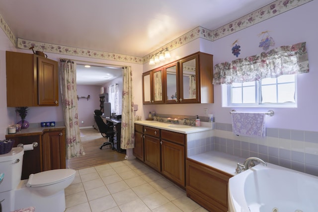 bathroom featuring toilet, a tub with jets, tile patterned flooring, and vanity