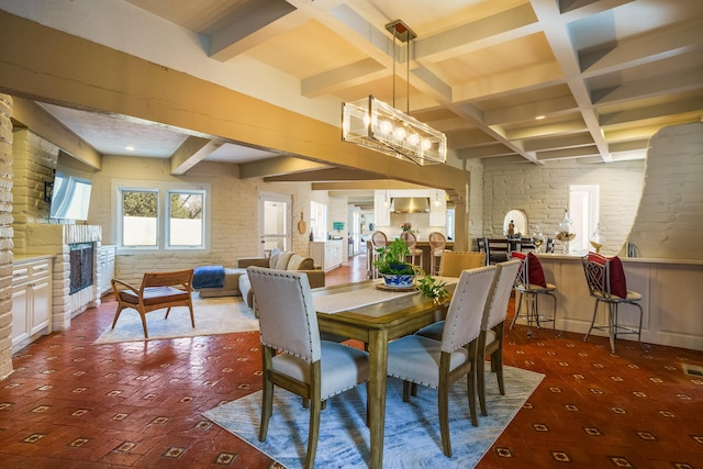 dining space featuring coffered ceiling, beamed ceiling, and brick wall