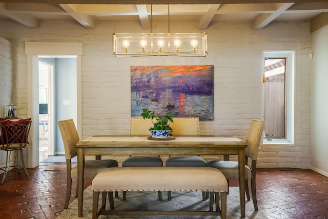 dining space with beam ceiling and brick wall