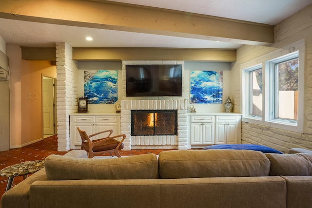 living room with beam ceiling, carpet, and a brick fireplace