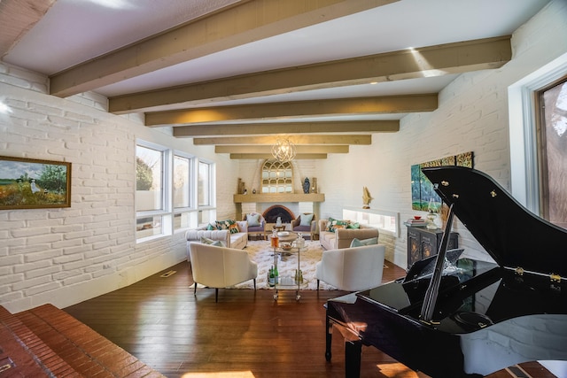 living room with dark wood-type flooring, beamed ceiling, and brick wall