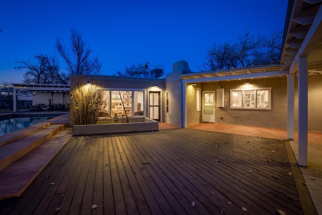 deck at night featuring a pergola