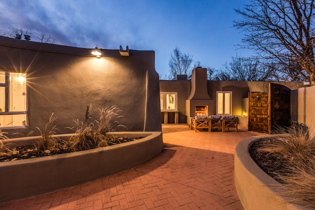 patio terrace at dusk with an outdoor fireplace