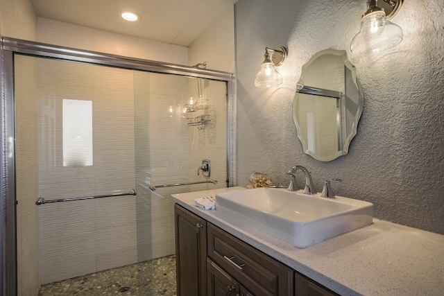 bathroom featuring vanity and a shower with shower door