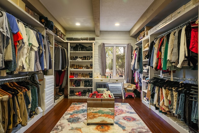 spacious closet with dark hardwood / wood-style flooring and beam ceiling