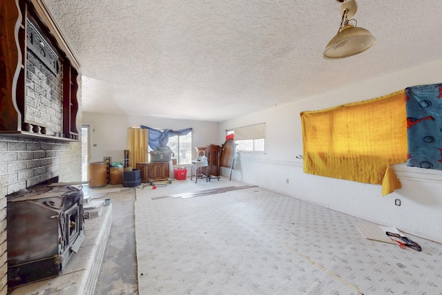 interior space with a wood stove and a textured ceiling