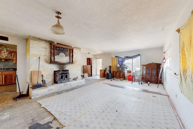 living room with a textured ceiling and a wood stove