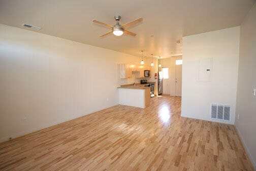 unfurnished living room featuring light hardwood / wood-style flooring and ceiling fan