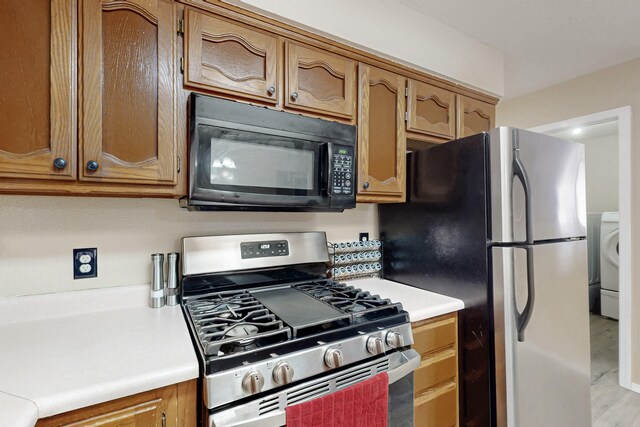 kitchen featuring appliances with stainless steel finishes and washer / dryer