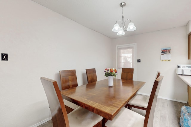 dining area with a chandelier and wood-type flooring