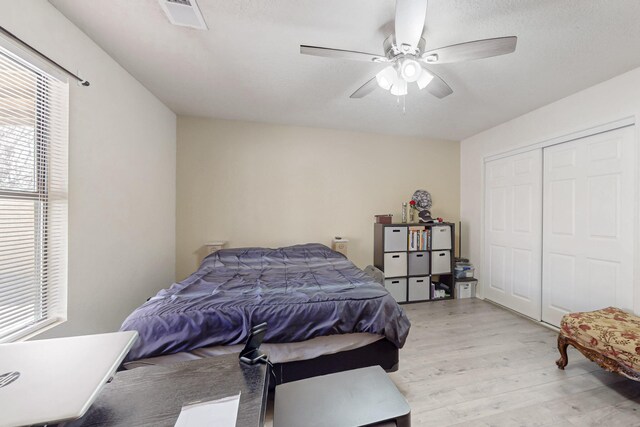bedroom featuring ceiling fan, light hardwood / wood-style flooring, and a closet