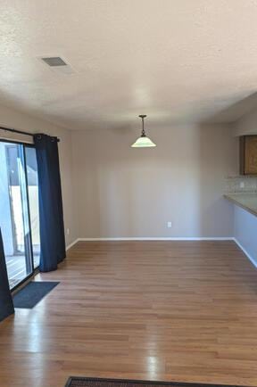 unfurnished living room with wood-type flooring and a textured ceiling