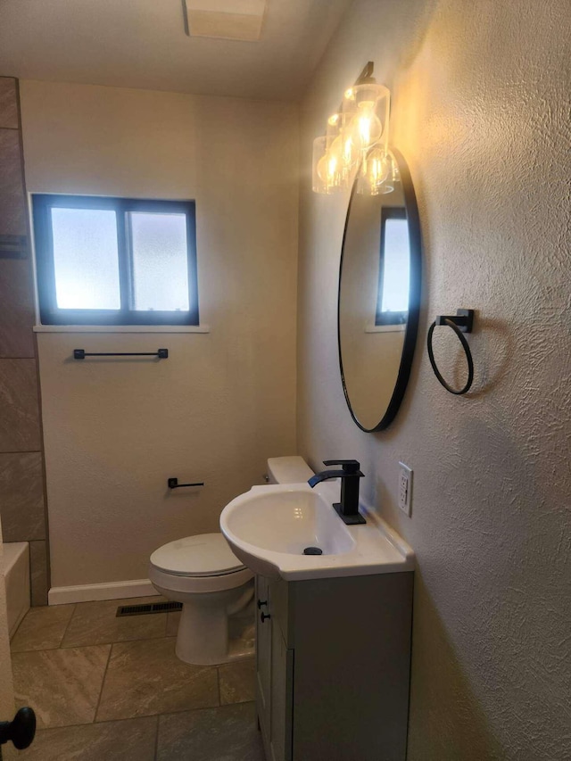 bathroom with a washtub, toilet, and vanity