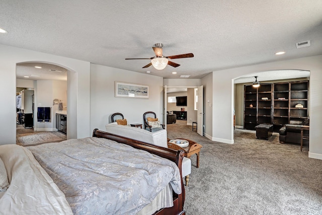 carpeted bedroom with visible vents, arched walkways, a textured ceiling, and recessed lighting