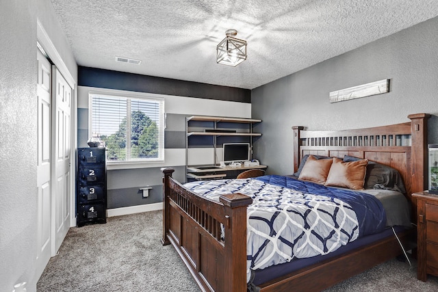 carpeted bedroom featuring a textured ceiling, a textured wall, visible vents, baseboards, and a closet