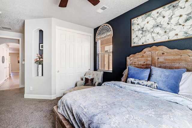 carpeted bedroom featuring a closet, visible vents, and a textured ceiling