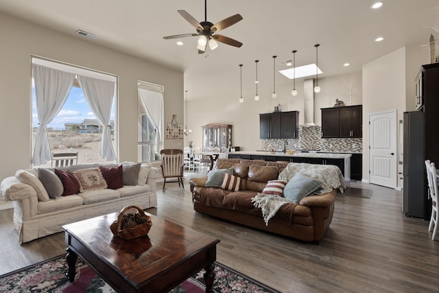 living room featuring ceiling fan, a high ceiling, and dark hardwood / wood-style floors