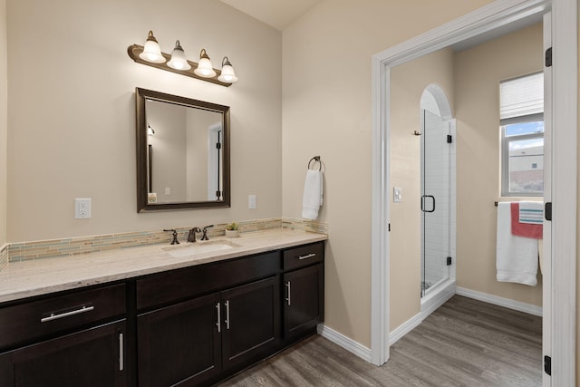 bathroom with wood-type flooring, an enclosed shower, and vanity