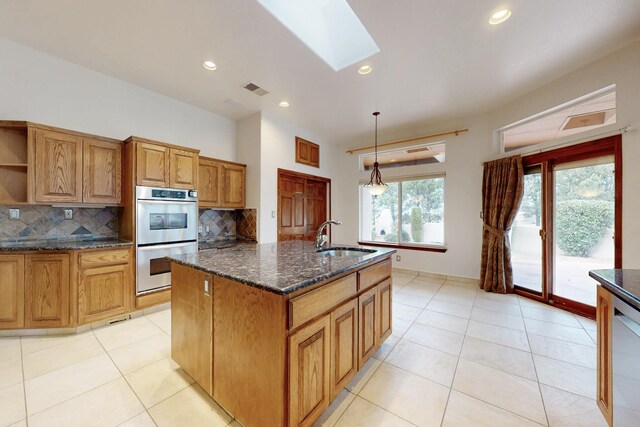 kitchen featuring open shelves, stainless steel double oven, decorative backsplash, and a sink