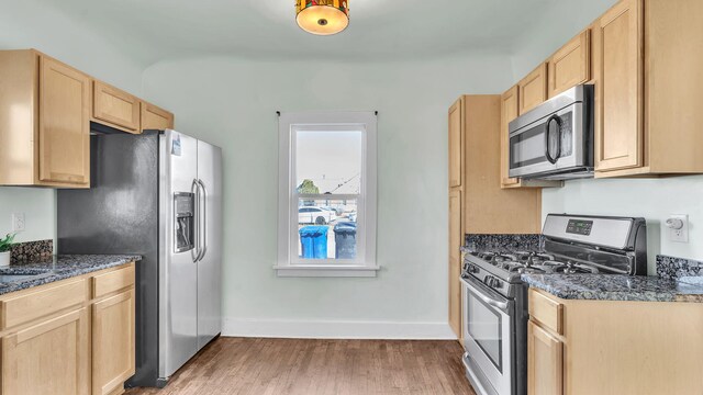 kitchen featuring light wood-style floors, baseboards, appliances with stainless steel finishes, and light brown cabinetry