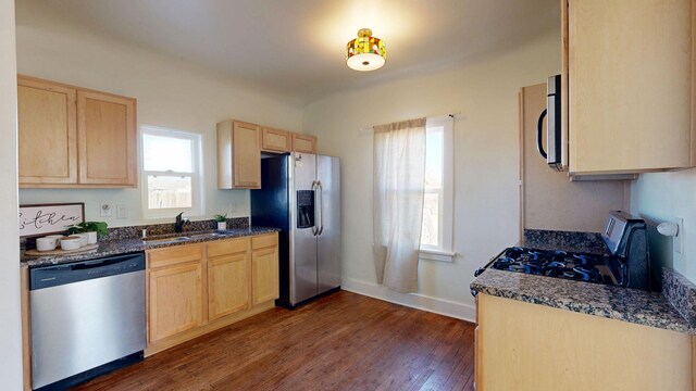 kitchen featuring a sink, appliances with stainless steel finishes, light brown cabinets, and dark wood finished floors