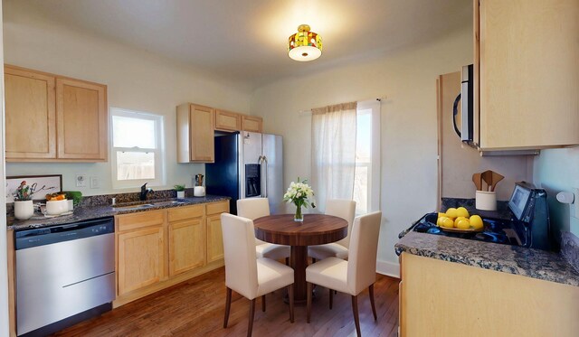 kitchen featuring dark wood-style floors, stainless steel appliances, a sink, and light brown cabinetry