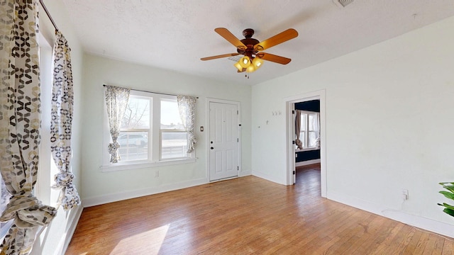 entryway with light wood-style floors, ceiling fan, and baseboards