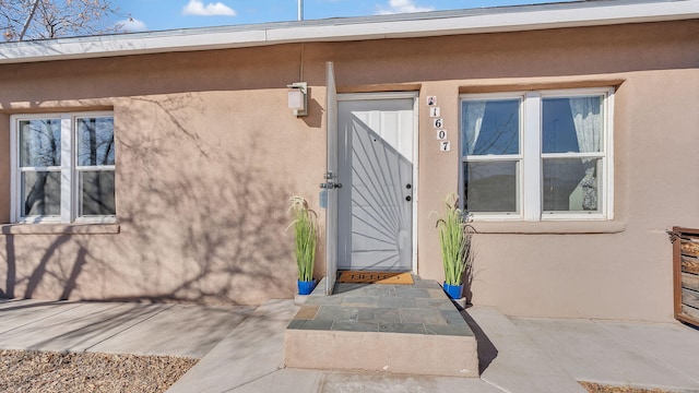 view of exterior entry with stucco siding