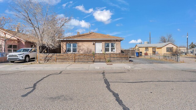 back of property with a shed, an outdoor structure, and a fenced backyard