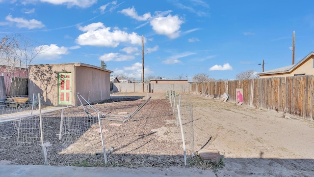 view of yard with a shed, fence, and an outbuilding