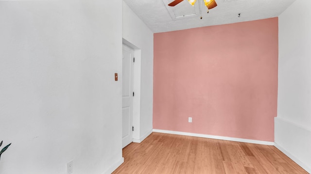 spare room featuring a ceiling fan, baseboards, a textured ceiling, and light wood finished floors