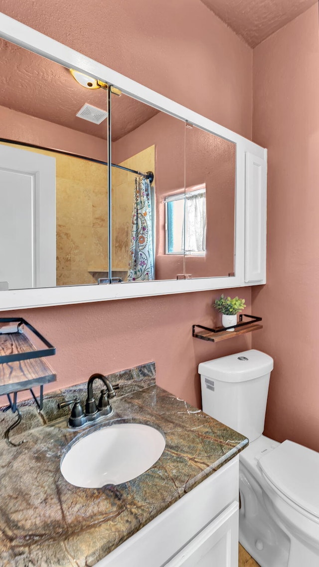 full bath featuring toilet, visible vents, a shower with shower curtain, and vanity