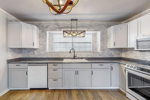 kitchen featuring dark countertops, white cabinetry, a sink, and stainless steel electric range