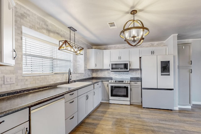 kitchen with electric range, white cabinetry, smart refrigerator, dark countertops, and dishwasher