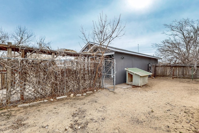 view of outdoor structure with fence and an outbuilding