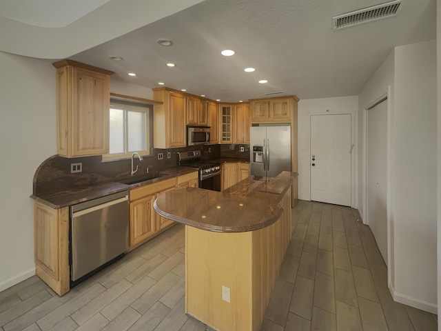 6737 Gleason Ave NW, Albuquerque, NM 87120 - kitchen featuring a kitchen island, visible vents, a sink, appliances with stainless steel finishes, and glass insert cabinets
