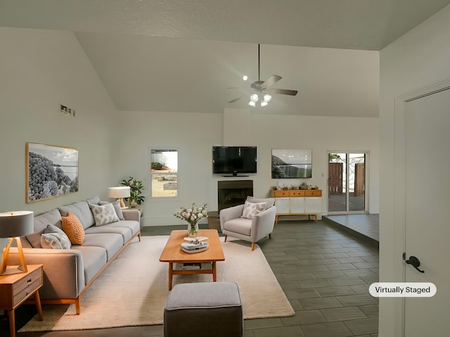 living area featuring high vaulted ceiling, ceiling fan, visible vents, and a fireplace