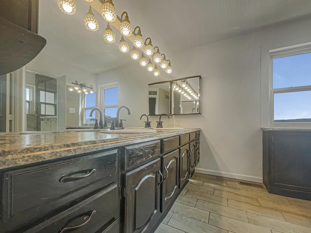 6737 Gleason Ave NW, Albuquerque, NM 87120 - full bathroom with double vanity, visible vents, baseboards, wood finish floors, and a sink