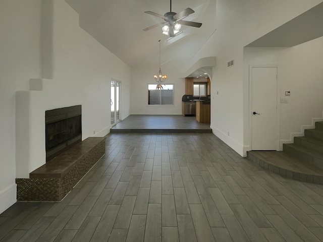 6737 Gleason Ave NW, Albuquerque, NM 87120 - unfurnished living room featuring wood tiled floor, visible vents, a tiled fireplace, and ceiling fan with notable chandelier