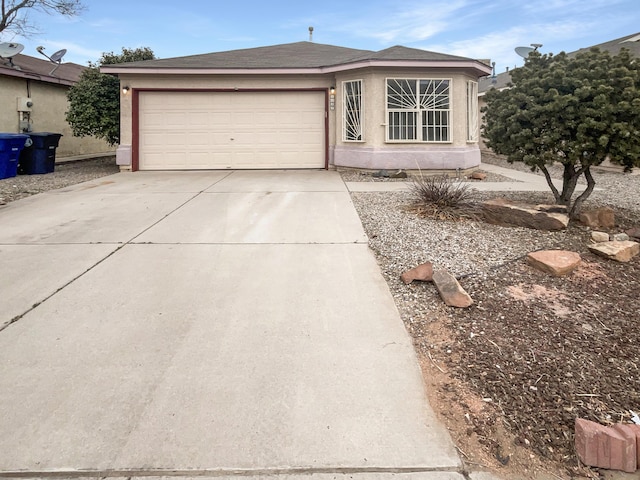 ranch-style house featuring concrete driveway, an attached garage, and stucco siding