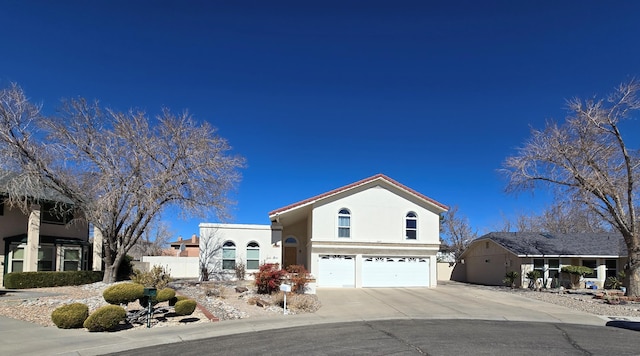 view of front facade featuring driveway, an attached garage, and stucco siding