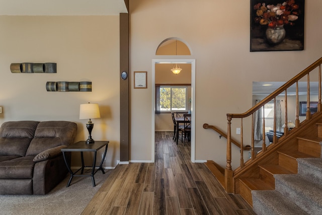 foyer entrance with stairway, dark wood-style flooring, and baseboards