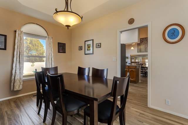 dining space with baseboards and wood finished floors