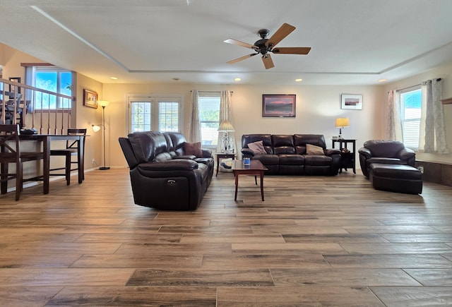 living room with ceiling fan, baseboards, wood finished floors, and a healthy amount of sunlight